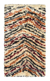 Overhead view of a deeply plush, intensely shaggy handmade 1970s vintage Moroccan wool accent rug named Deep Down (2'8" x 4'8") featuring a thick cream base covered in undulating, wavy chevron lines woven in black, rust orange, and a rare dark ox-blood red, with a 1-inch pile.