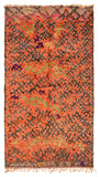 Overhead view of a massive, room-sized handmade 1960s vintage Boujad Moroccan wool area rug named Wild Ride (6'2" x 12') featuring an intense bright orange base covered in a chaotic, frantic dark charcoal geometric lattice, accented with free-floating neon green and purple tribal motifs, with a 3/4-inch pile.