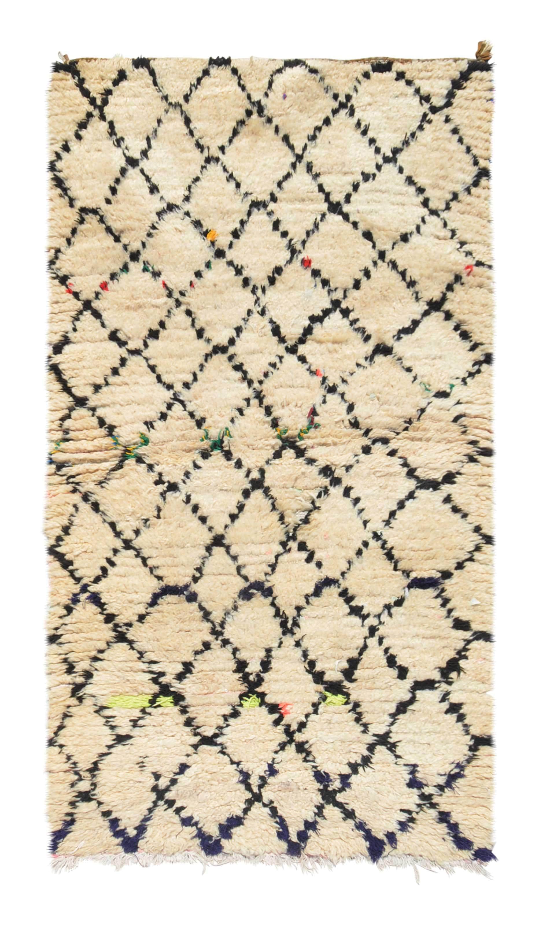 Overhead view of a deeply plush, classic handmade 1970s vintage Beni Ourain Moroccan wool accent rug named Fine Day (3' x 5'8") featuring a thick cream base covered in a dark geometric diamond lattice, punctuated by tiny, unexpected flecks of fluorescent orange, yellow, and green yarn, with a 3/4-inch pile.