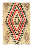 Overhead view of a deeply plush, room-commanding handmade vintage Beni Ourain Moroccan wool area rug named Purposeful (3'10" x 6') featuring a thick cream base dominated by a massive, concentric geometric diamond medallion woven with jagged black and red lines, anchored by muted brown corner motifs, with a 1-inch pile.