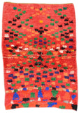 Overhead view of a highly vibrant, deeply plush handmade 1990s vintage Boucherouite Moroccan cotton area rug named Crazy Good (4'3" x 5'10") featuring a bright red background scattered with pixelated, blocky geometric motifs woven in green, blue, black, white, and orange, with a 1-inch pile.