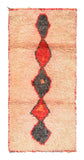 Overhead view of a fabulously soft handmade 1960s vintage Boujad Moroccan wool rug named Hopeful (3'5" x 7'5") featuring a sun-faded peach and apricot base with a central vertical column of connected geometric diamonds woven in dark charcoal and bright red, framed by red edges, with a 3/4-inch pile.