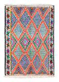 Overhead view of a highly vibrant, heavily detailed handmade 1960s vintage Azilal Moroccan cotton area rug named Truly Living (5'8" x 8'2") featuring a dense pattern of interlocking geometric diamonds outlined in neon orange with speckled blue and purple centers, framed by a colorful floral star border, with a 3/4-inch pile.