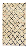 Overhead view of a deeply plush, classic handmade 1970s vintage Beni Ourain Moroccan wool accent rug named Fine Day (3' x 5'8") featuring a thick cream base covered in a dark geometric diamond lattice, punctuated by tiny, unexpected flecks of fluorescent orange, yellow, and green yarn, with a 3/4-inch pile.