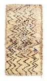 Overhead view of a very soft, deeply plush handmade 1970s vintage Beni Ourain Moroccan wool and cotton accent rug named Static (2'10" x 5'8") featuring a cream base covered in energetic, jagged dark brown zigzag lines resembling visual static, with tiny hidden pops of blue and pink, and a 1-inch pile.
