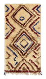 Overhead view of a deeply plush, highly textured handmade 1970s vintage Azilal Moroccan wool and cotton accent rug named Stronger (2'8" x 5'2") featuring a cream base covered in large, bold, nested geometric diamonds woven with jagged lines of navy blue, burgundy red, and earthy brown, with a 1-inch pile.