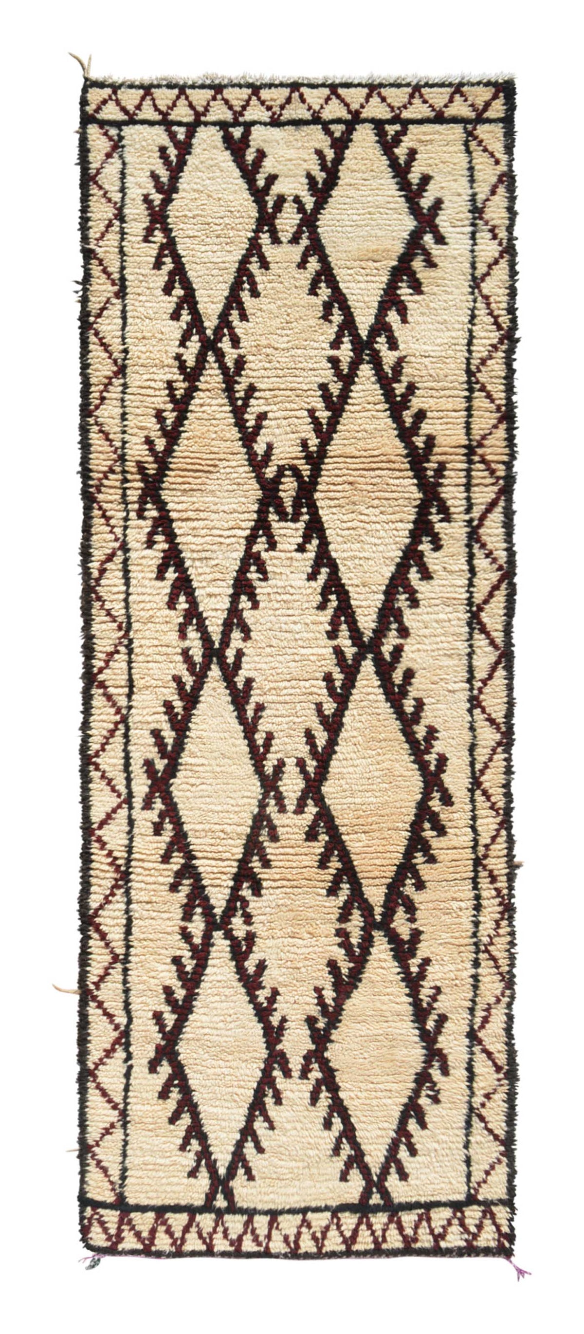 Overhead view of a deeply plush, highly structured handmade 1960s vintage Beni Ourain Moroccan wool and cotton runner rug named Riptide (3'5" x 9'7") featuring a cream base framed by a dark border, with three large, connected central diamonds displaying toothed, comb-like jagged edges woven in rare, deep ox blood red yarn, with a 3/4-inch pile.